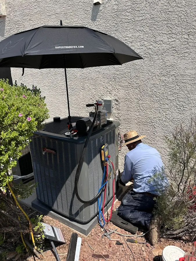 HVAC technician performing outdoor AC maintenance in Cuero